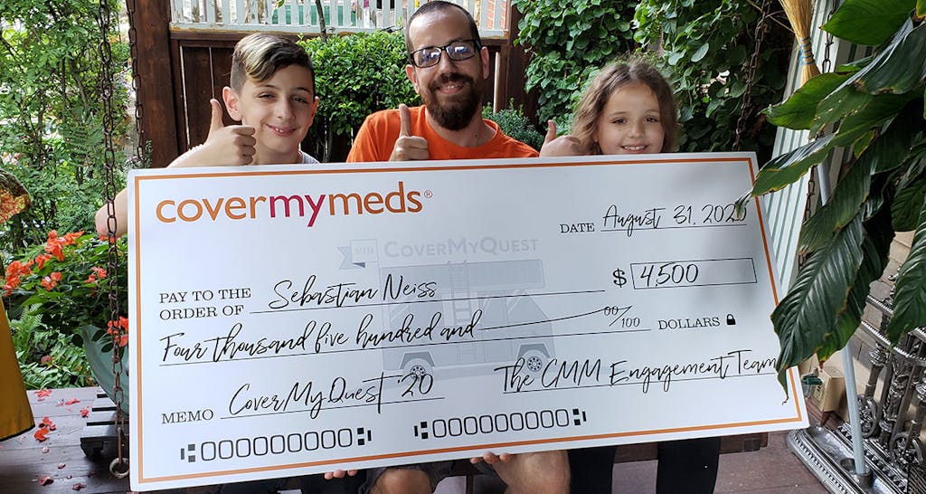 A photo of Sebastian and his chidren with his quest grant check.