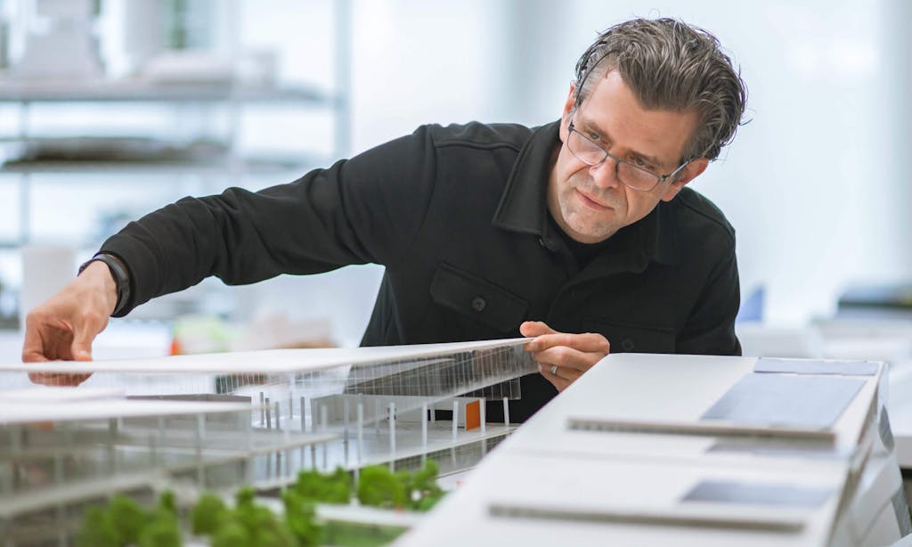 An architect tinkers with a model of the CoverMyMeds campus. 